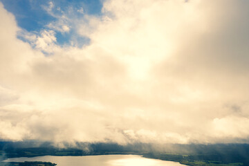 Obraz premium Aerial view clouds over the forest and lake. View from drone. Aerial top view cloudscape. Texture of clouds. View green forest from above covered with white clouds