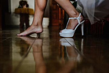 bride shoes. Woman putting on white high heels to leave home