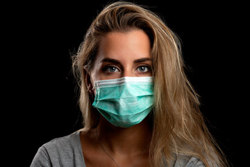 beautiful blonde woman with protective mask against covid19 on black background