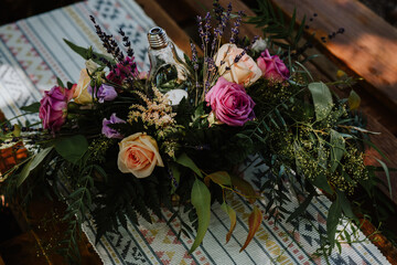 fashioned roses. beautiful country style centerpiece with roses. Recycled pallet table with vintage-style fabric tablecloth