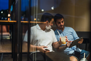 Dos jovenes mirando tablet mientras toman cafe