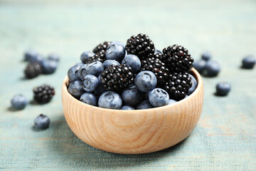 Blueberries and blackberries on blue wooden table