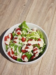 Green vegan salad from green leaves mix and vegetables. eat clean  for heaalthy.Top view on gray stone table.