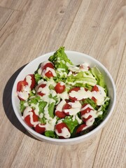 Green vegan salad from green leaves mix and vegetables. eat clean  for heaalthy.Top view on gray stone table.