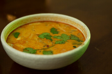 Plate with tom yum soup on a wooden table