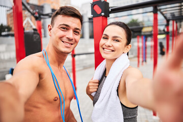 Happy loving couple exercising together on sports ground