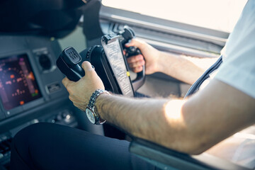 Male pilot is driving airplane in cockpit