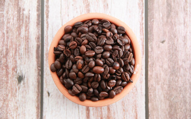natural black coffee beans in a ceramic plate