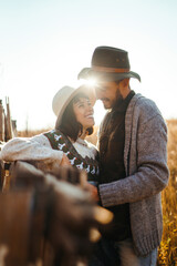 Stylish hipster couple outdoors on a beautiful autumn day in the park. Young couple in love  hugging and enjoying each other at sunset. The concept of youth, love and lifestyle.
