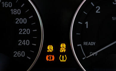 Closeup of lose tyre pressure with Stability control system alert in dashboard car on background.	
