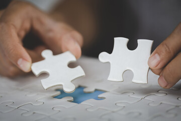 Two hands of businessman to connect couple puzzle piece. symbol of association and connection. business strategy.