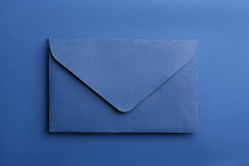 Paper envelope on blue background, top view