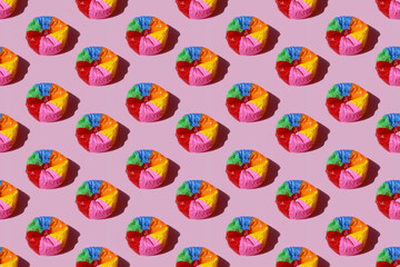 Imagen de balon de playa desinflado con rayas de colores sobre fondo rosa pastel © minerva