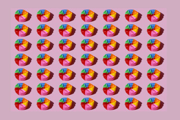Imagen de balon de playa desinflado con rayas de colores sobre fondo rosa pastel © minerva