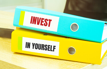 Two office folders with text INVEST IN YOURSELF