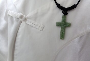 The cross is made of green jade.  Hanging on a man in white