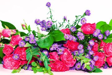 A bouquet of pink roses and purple chrysanthemums with green leaves on a white background.Beautiful floral background with copy space for teacher's, mother's, Valentine's day holiday greeting card