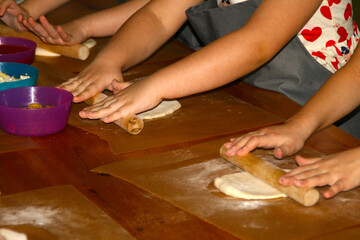 Children's hands close-up preparing dough products.