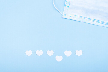 Medical mask and paper white hearts. Flat lay, copy space. Save life and health concept.