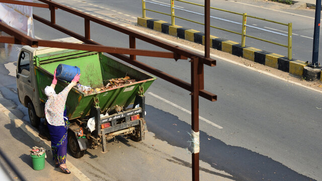 Women Sanitation Worker Collecting Garbage Of A Locality During Lock Down.