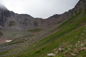 Mountain range in the clouds. Mountain pass in the fog. Pass Pastushiy (3244 meters above sea level), Caucasus.