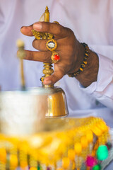 close up of the hand of a  balinese priest giving a blessing during a ceremony