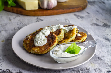 unsweetened cottage cheese pancakes with white sauce on a light background