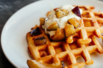 Delicious Viennese waffles on a plate. Waffles with sour cream, honey and fruits