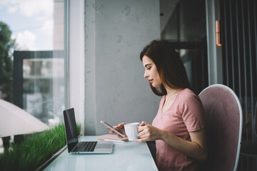 Concentrated woman using gadgets in cafe