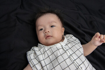 Portraiture image of Three month old Asian Cute little baby boy lsolated on Black