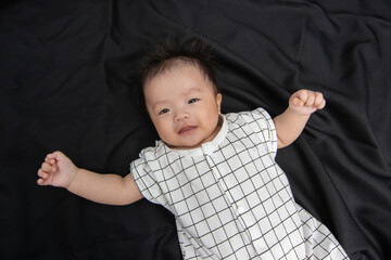 Portraiture image of Three month old Asian Cute little baby boy lsolated on Black