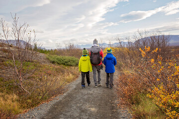 Mother with children, walking on a path in scenic Thingvellir National Park rift valley, Iceland