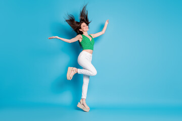 Full body photo of candid content charming girl jump enjoy rejoice air fly haircut blow hold hands raise wear good look outfit shoes isolated over blue color background