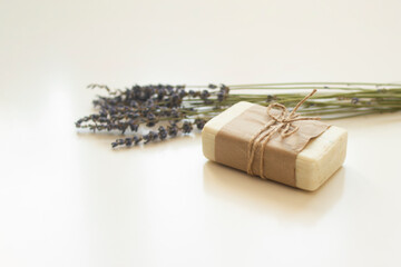 A piece of soap in a crafted box with lavender in the background.