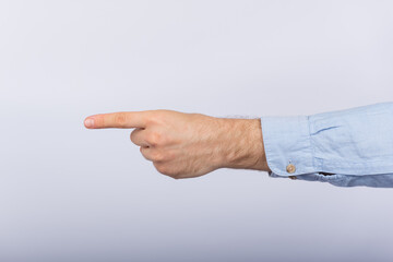 Male hand shows direction of index finger. Pointing hand on white background.
