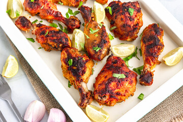 Spicy BBQ Grilled Chicken on a Baking Sheet Garnished with Cilantro, Green Chili Pepper and Lemon,  Top Down Close Up Chicken Photo