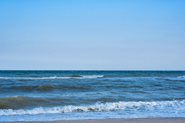Sea against the blue sky. Waves and white foam. Vacation at sea