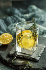 Alcoholic cocktail with rum lemon, thyme and ice. Low shallow focus