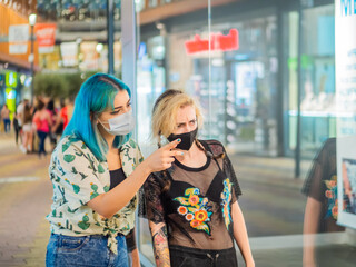 Mujeres jóvenes yendo de compras aprovechando el black friday durante la pandemia del coronavirus respetando las medidas de seguridad y distanciamiento social 