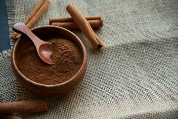 cinnamon sticks, tied with jute rope in rustic style. Ground cinnamon in a wooden bowl and vintage...