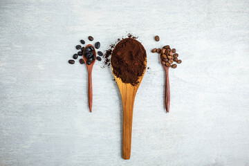 Coffee beans and coffee powder on a wooden spoon
