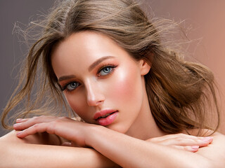 Fototapeta premium Beautiful white girl with red lips looks to the camera. Stunning blonda girl. Closeup face of young beautiful woman with a healthy clean skin. Pretty woman with bright makeup of eyes.