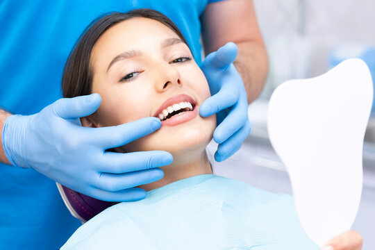 Attractive young woman in a dental clinic with a male dentist. Healthy teeth concept.