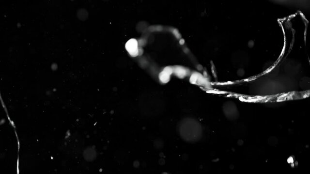 Super slow motion of shattered glass on black background. Filmed on high speed cinema camera, 1000 fps.