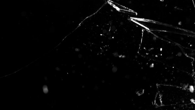 Super slow motion of shattered glass on black background. Filmed on high speed cinema camera, 1000 fps.