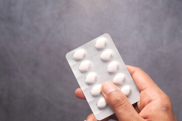  man hand holding blister pack isolated on black 