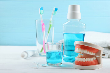 Dental model of teeth and dental care products on colored background with place for text