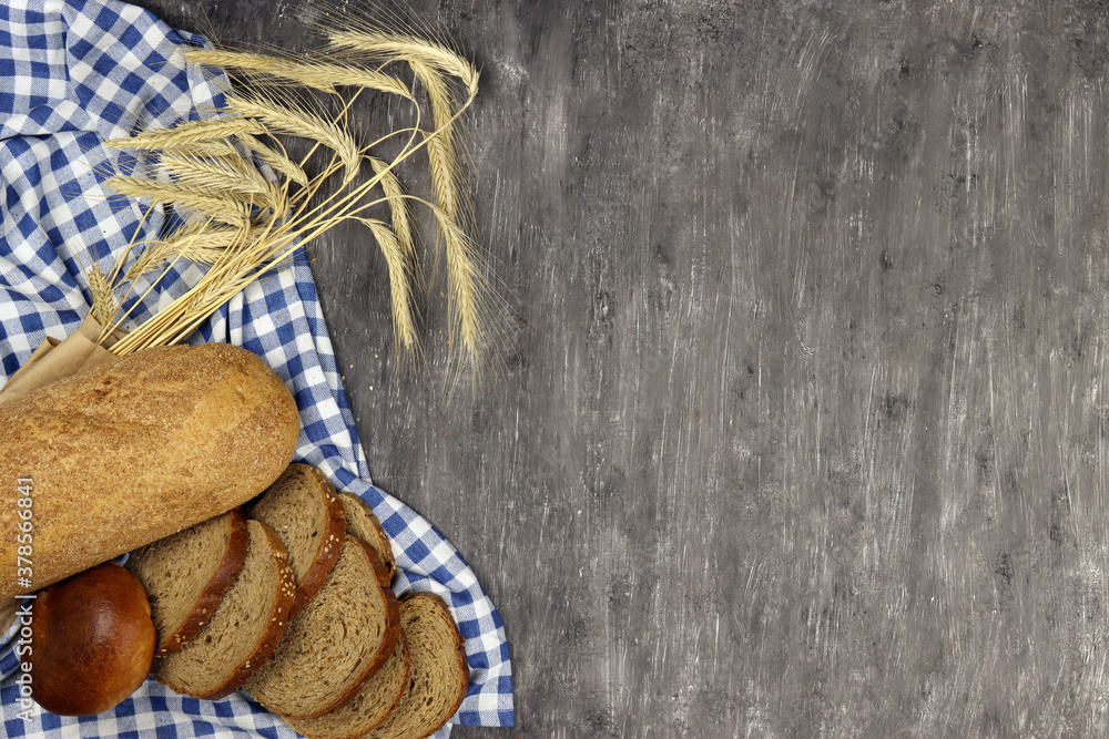 Poster Bakery product and wheat ears on a gray background. Copy space for text
