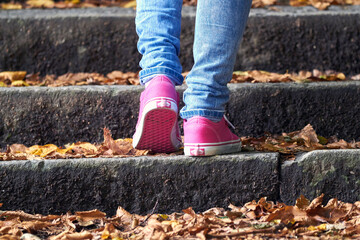 Woman in pink / purple canvas vintage shoes and blue jeans.