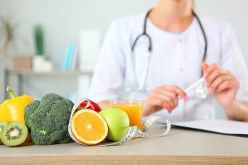 young doctor nutritionist in his office demonstrates the concept of healthy eating. Help with weight control
